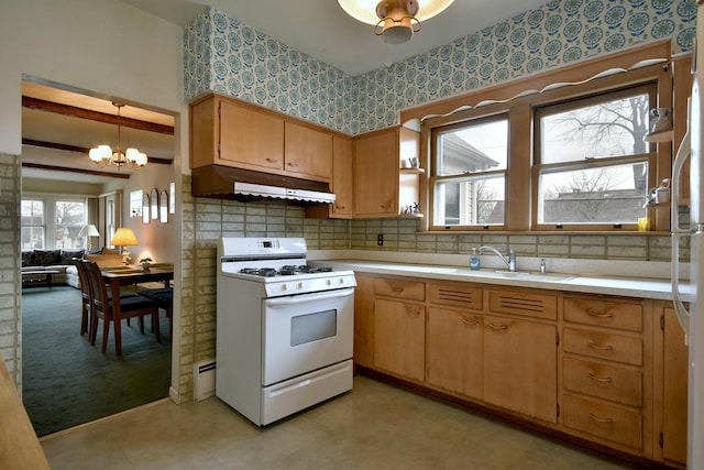 kitchen featuring tasteful backsplash, sink, a chandelier, hanging light fixtures, and gas range gas stove