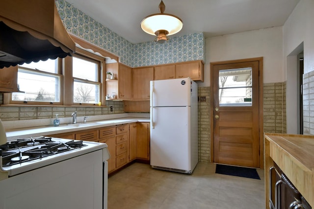 kitchen with sink, backsplash, and white appliances