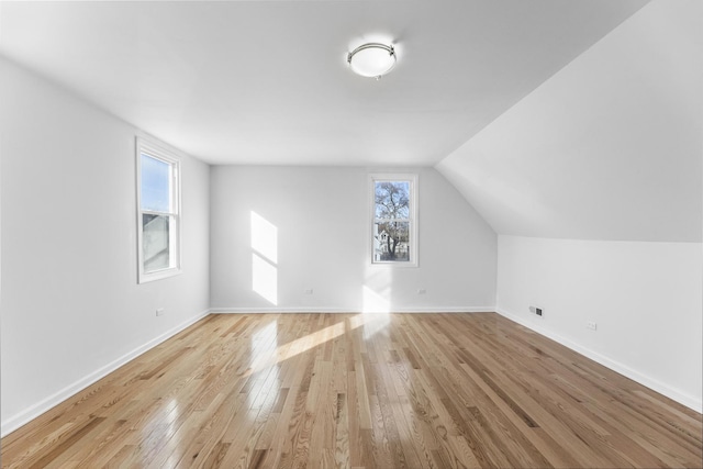 bonus room featuring lofted ceiling and light hardwood / wood-style flooring