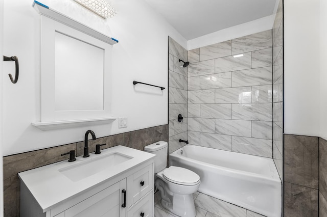 full bathroom featuring tile walls, vanity, toilet, and tiled shower / bath