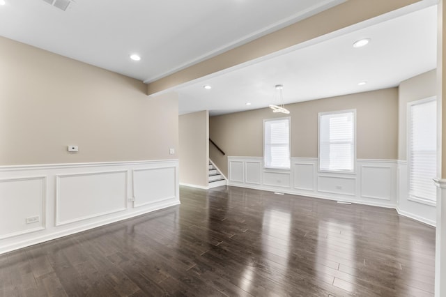 unfurnished room featuring dark wood-type flooring and beam ceiling