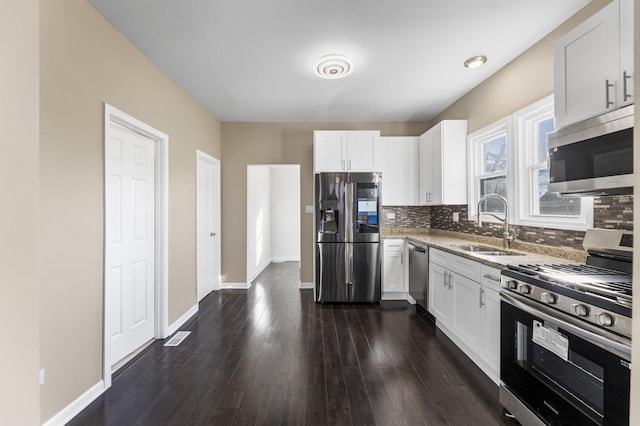 kitchen featuring tasteful backsplash, appliances with stainless steel finishes, sink, and white cabinets