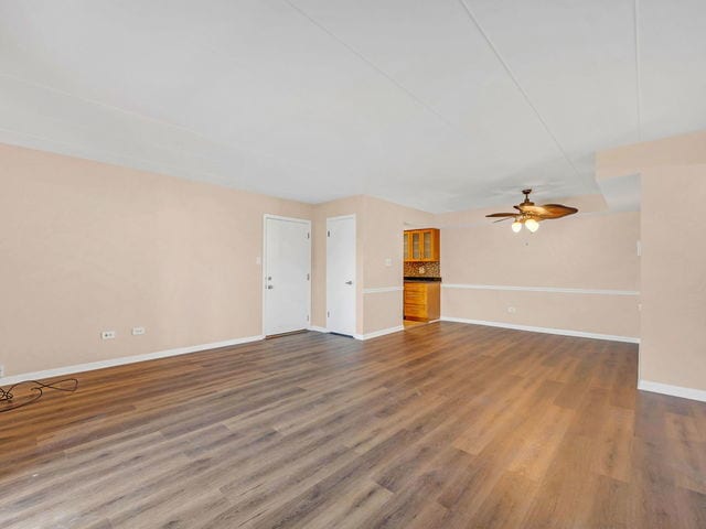 unfurnished living room with ceiling fan and dark hardwood / wood-style flooring