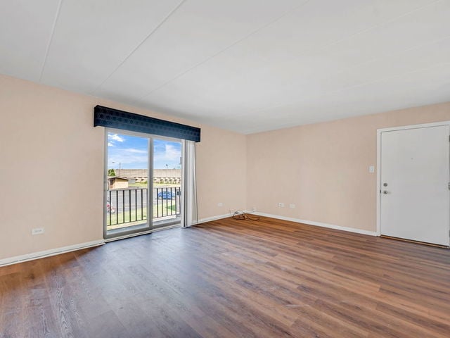 spare room with dark wood-type flooring