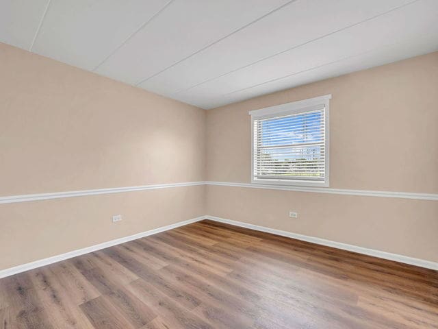 unfurnished room with wood-type flooring