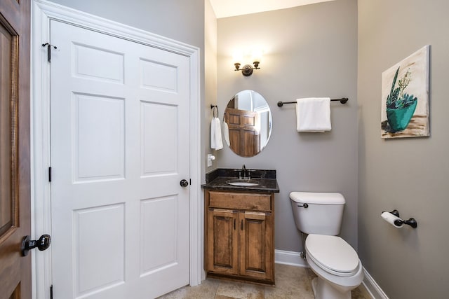 bathroom with toilet, baseboards, and vanity