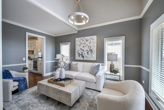 living room with ornamental molding, dark wood-style flooring, and a notable chandelier