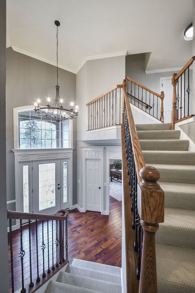 foyer entrance featuring stairs, high vaulted ceiling, dark wood-style flooring, and crown molding