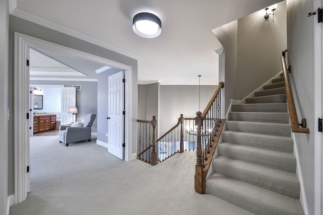 staircase with carpet floors, baseboards, and crown molding