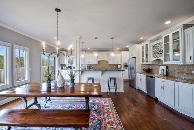 dining space with a notable chandelier, dark wood finished floors, crown molding, and recessed lighting