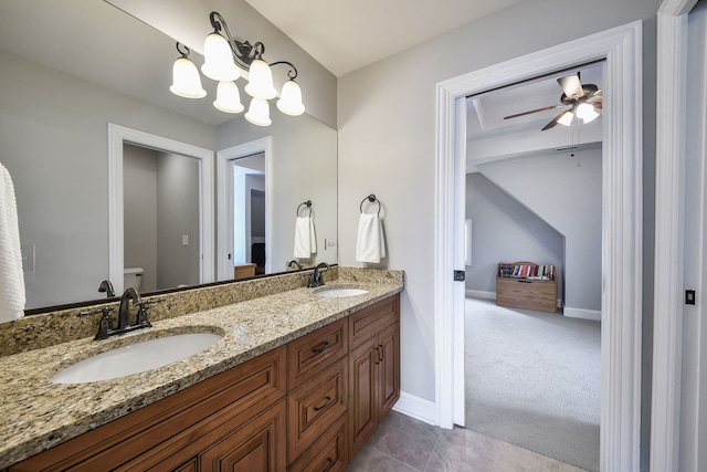 bathroom with toilet, double vanity, a sink, and tile patterned floors