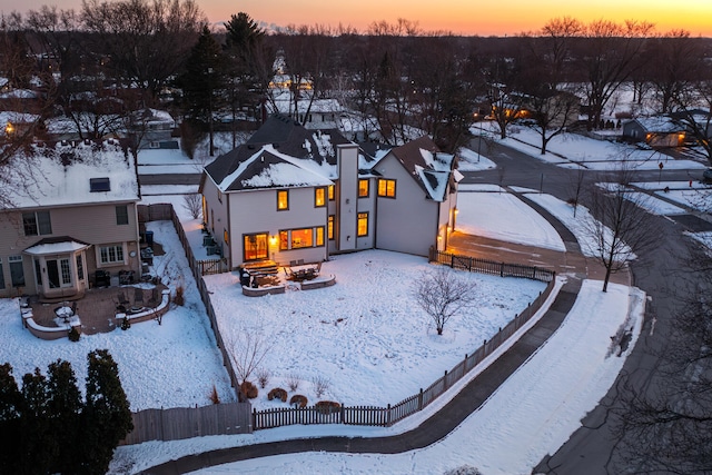 snow covered property with a patio, an outdoor fire pit, and a fenced backyard