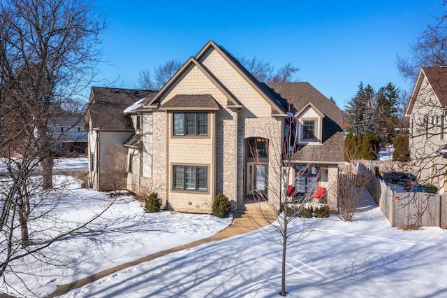 view of front of house featuring a shingled roof and fence