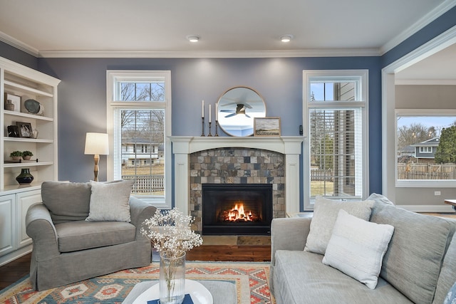 living area with wood finished floors, a tile fireplace, and crown molding