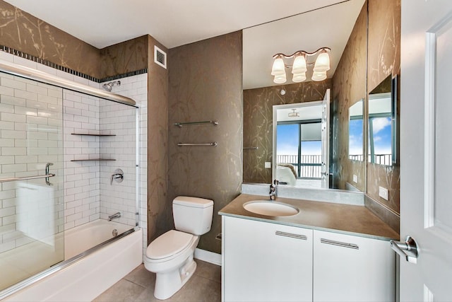 full bathroom with tile patterned floors, vanity, toilet, and combined bath / shower with glass door