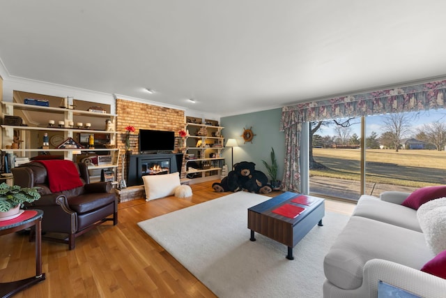 living room featuring ornamental molding, a fireplace, and hardwood / wood-style floors