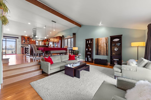 living room with light hardwood / wood-style flooring and lofted ceiling with beams