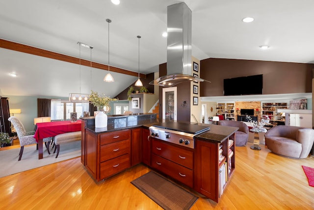 kitchen featuring hanging light fixtures, vaulted ceiling, stainless steel gas stovetop, and island exhaust hood