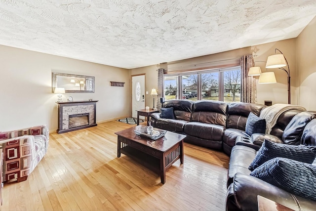 living room with hardwood / wood-style floors, a fireplace, and a textured ceiling