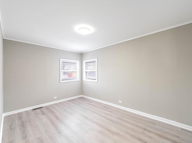 spare room featuring crown molding and light hardwood / wood-style flooring