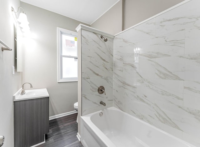 full bathroom with vanity, hardwood / wood-style floors, tiled shower / bath combo, and toilet