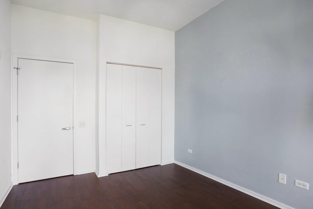 unfurnished bedroom featuring a closet and dark hardwood / wood-style floors