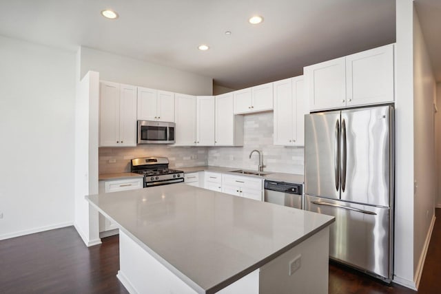 kitchen with sink, stainless steel appliances, white cabinets, and a kitchen island