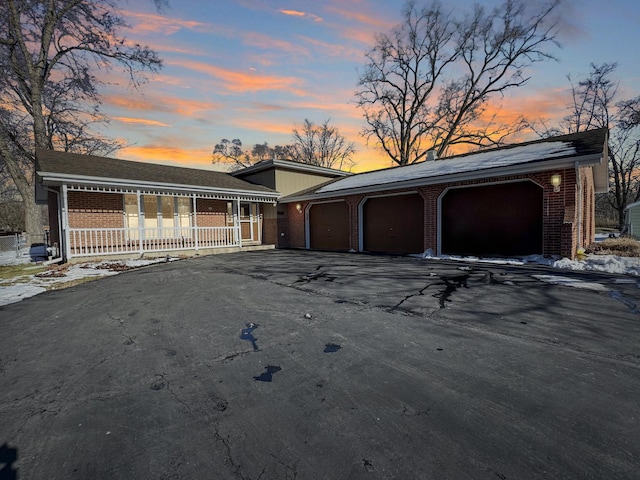 ranch-style house with a garage and covered porch