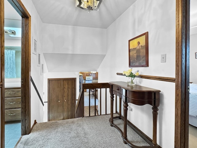 corridor with carpet and an inviting chandelier