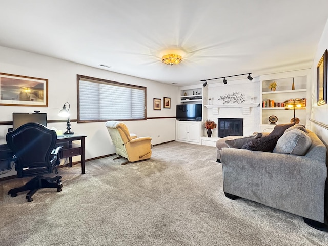 carpeted living room featuring a fireplace, built in features, and track lighting