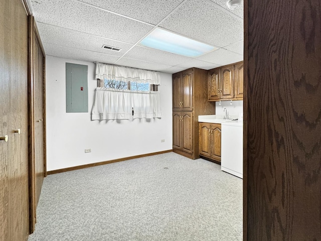 kitchen featuring washer / clothes dryer, light colored carpet, a paneled ceiling, and electric panel