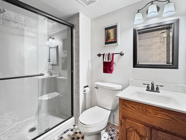 bathroom with vanity, toilet, and a shower with door