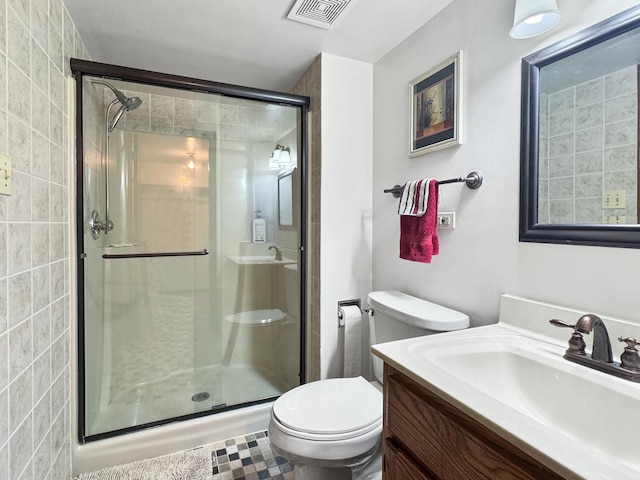 bathroom with vanity, a shower with shower door, and toilet