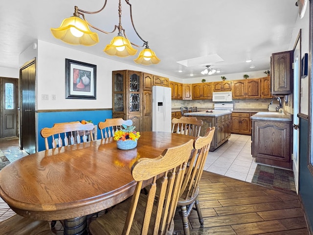 dining space featuring sink, light hardwood / wood-style flooring, and a skylight