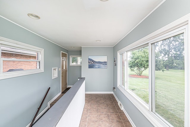 corridor with baseboards, ornamental molding, dark tile patterned flooring, and visible vents