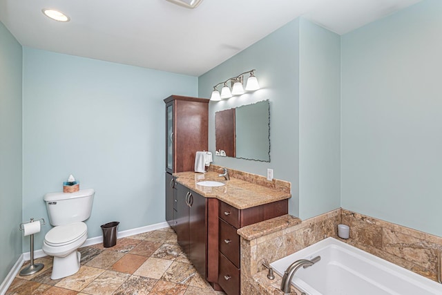 bathroom with toilet, stone tile flooring, vanity, baseboards, and a bath