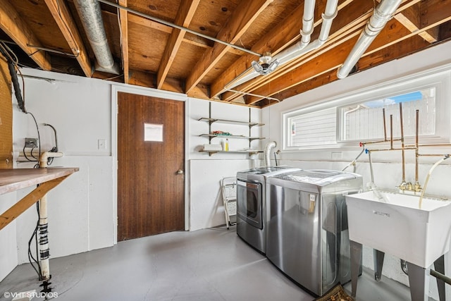 laundry area with laundry area, washer and clothes dryer, and a sink