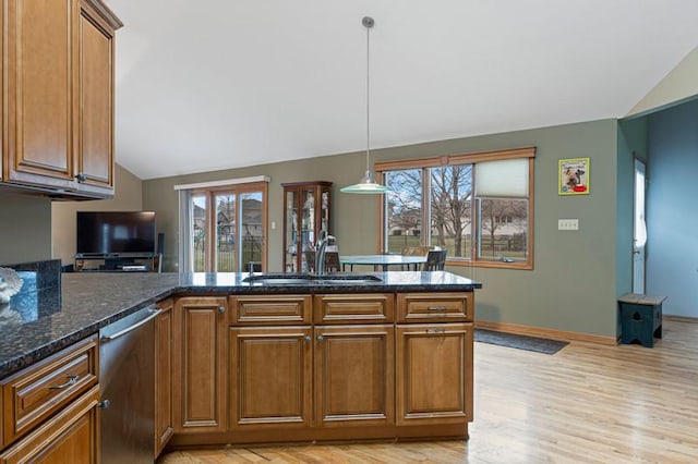 kitchen with dishwasher, vaulted ceiling, sink, and decorative light fixtures