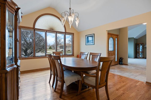 dining room featuring lofted ceiling, a chandelier, and light hardwood / wood-style flooring