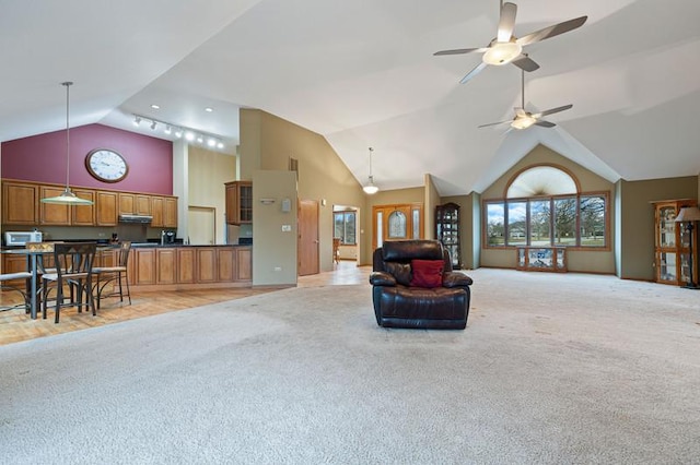 living room featuring ceiling fan, light colored carpet, and high vaulted ceiling