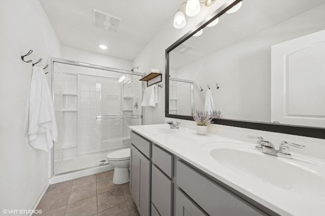 full bathroom featuring visible vents, a sink, a shower stall, and toilet