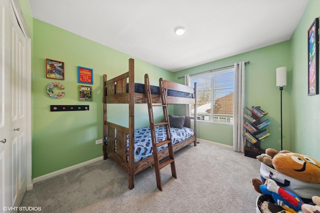 carpeted bedroom featuring a closet and baseboards