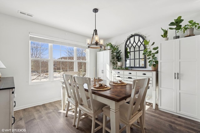 dining space with a chandelier, visible vents, dark wood finished floors, and baseboards