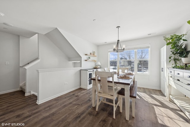 dining space with visible vents, dark wood finished floors, baseboards, and an inviting chandelier