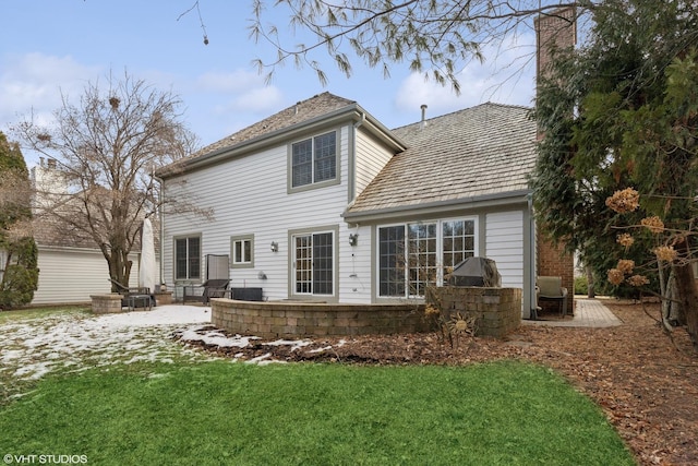 rear view of house with a patio and a lawn