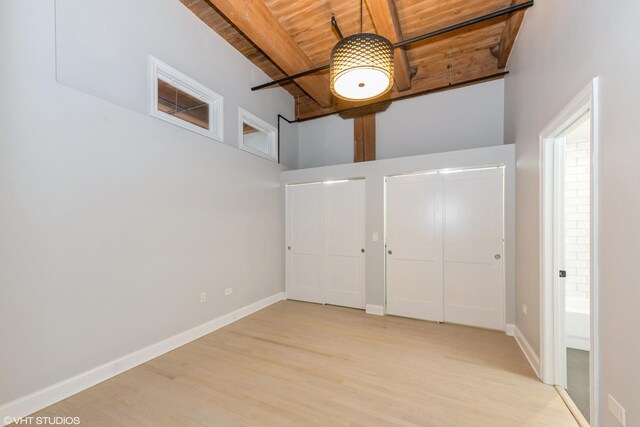 entrance foyer with light wood-style floors, beamed ceiling, wood ceiling, and baseboards