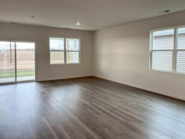 unfurnished room with dark hardwood / wood-style floors and a wealth of natural light