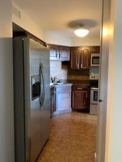 kitchen with range with electric stovetop, tasteful backsplash, sink, and stainless steel fridge with ice dispenser