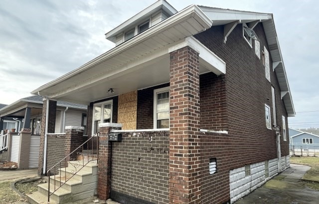 view of side of property featuring covered porch