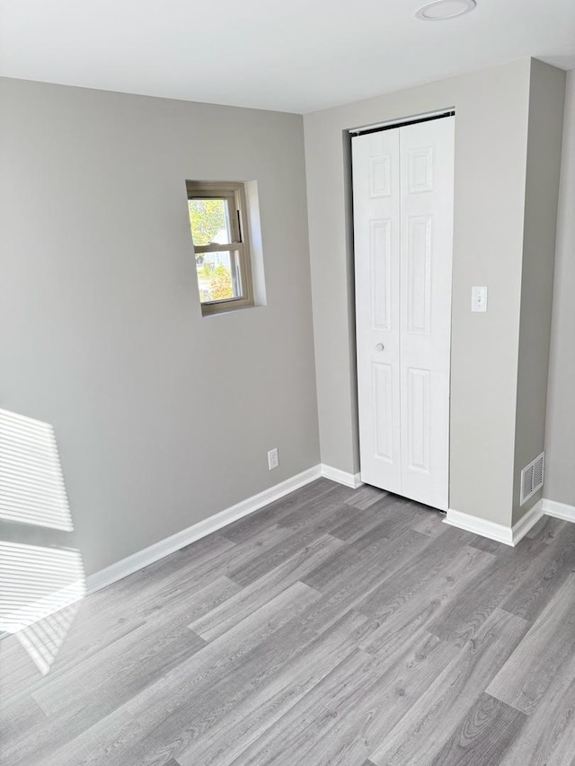 unfurnished bedroom featuring a closet and light wood-type flooring